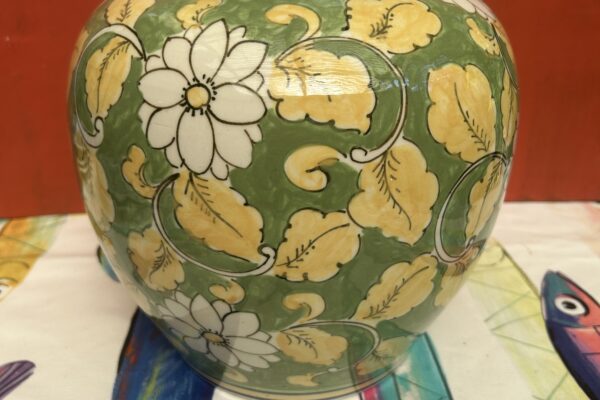 Groene Chinese dekselpot met witte bloemen, en gele bladeren