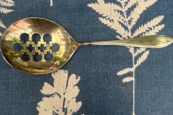 Grote verzilverde uitlek opscheplepel, met uitgezaagd patroon Keltum